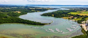 Aerial view of Buckler's Hard Yacht Harbour and Beaulieu River moorings stretching down to the Solent
