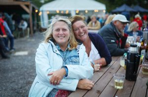 Two mooring holders sat together on a picnic bench smiling for the camera