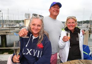 Three mooring holders smiling for the camera in front of the river