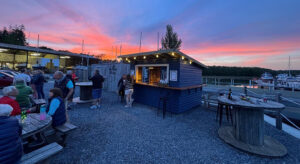 The sun setting behind the Boatyard Bar - mooring holders are enjoying a drink on the benches in front of the bar