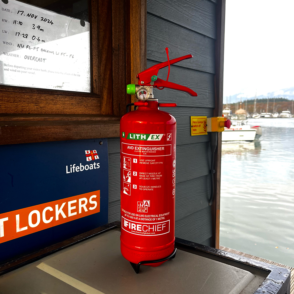 A fire extinguisher in front of the river